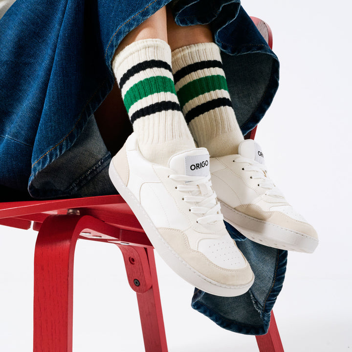 Zapatillas barefoot Origo Retro Gen 2 White blancas, puestas con calcetines a rayas, sentada