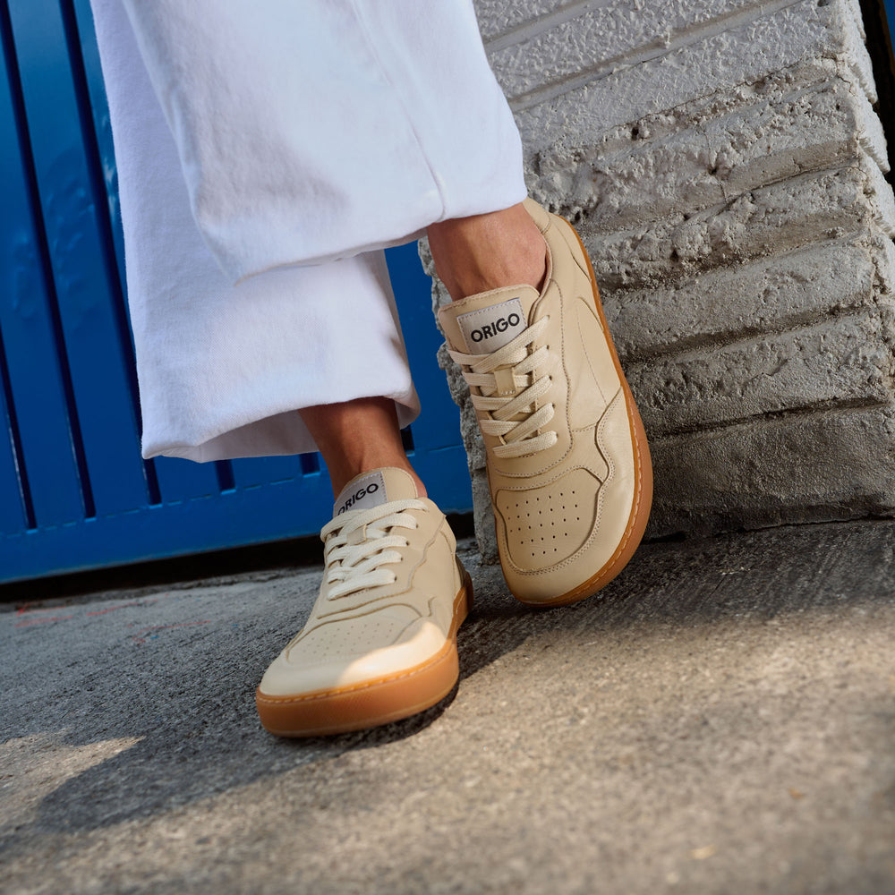 Zapatillas barefoot Origo Retro Gen 2 Sand, puestas con pantalón blanco